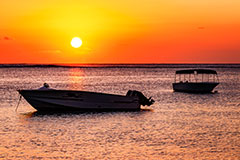 Sonnenuntergang mit Booten am Meer